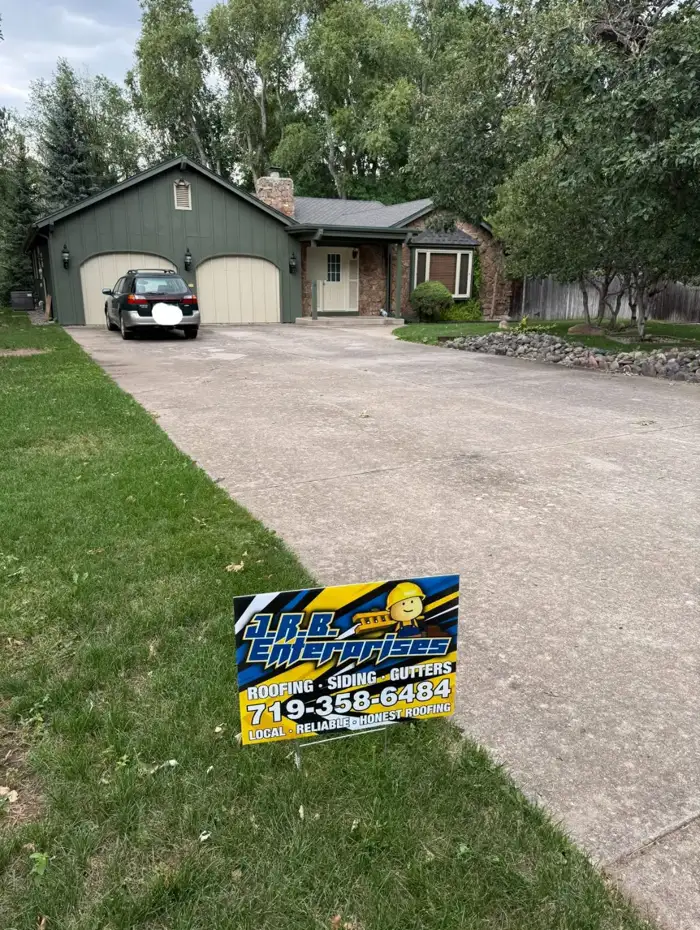 New roof on a green home with a J.R.B. yard sign